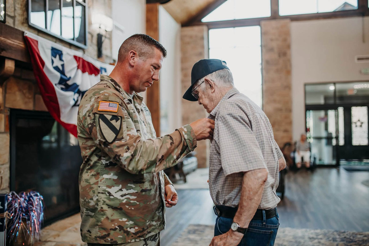 military member pinning a veteran during ceremony at The Arbors in Russellville, AR
